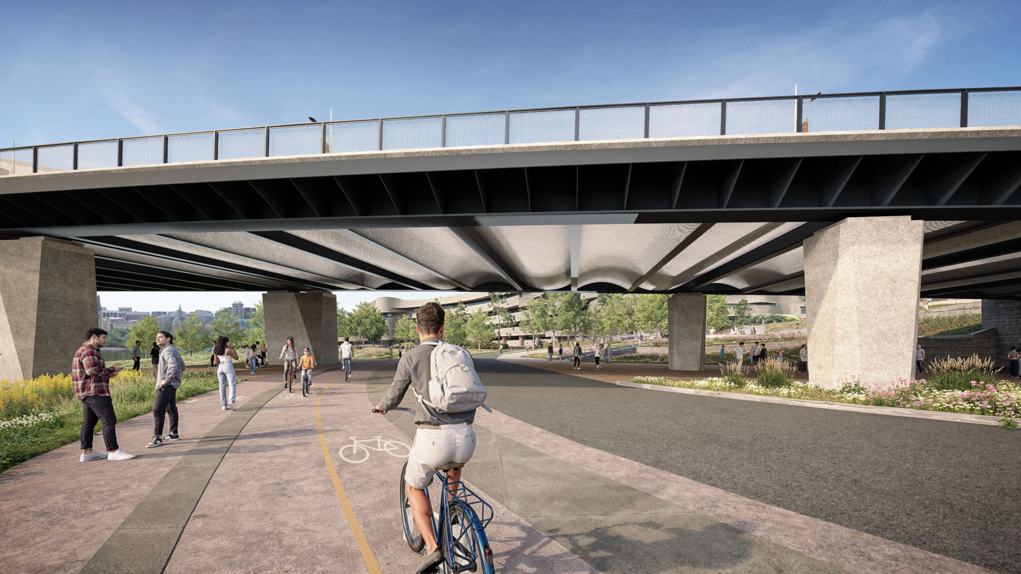 Pathway continuing under the bridge approach in Gatineau and connecting to the Voyageurs pathway. People are walking and biking on the pathway, surrounded by greenery and trees. The bridge structure with concrete supports and metal railings is visible.