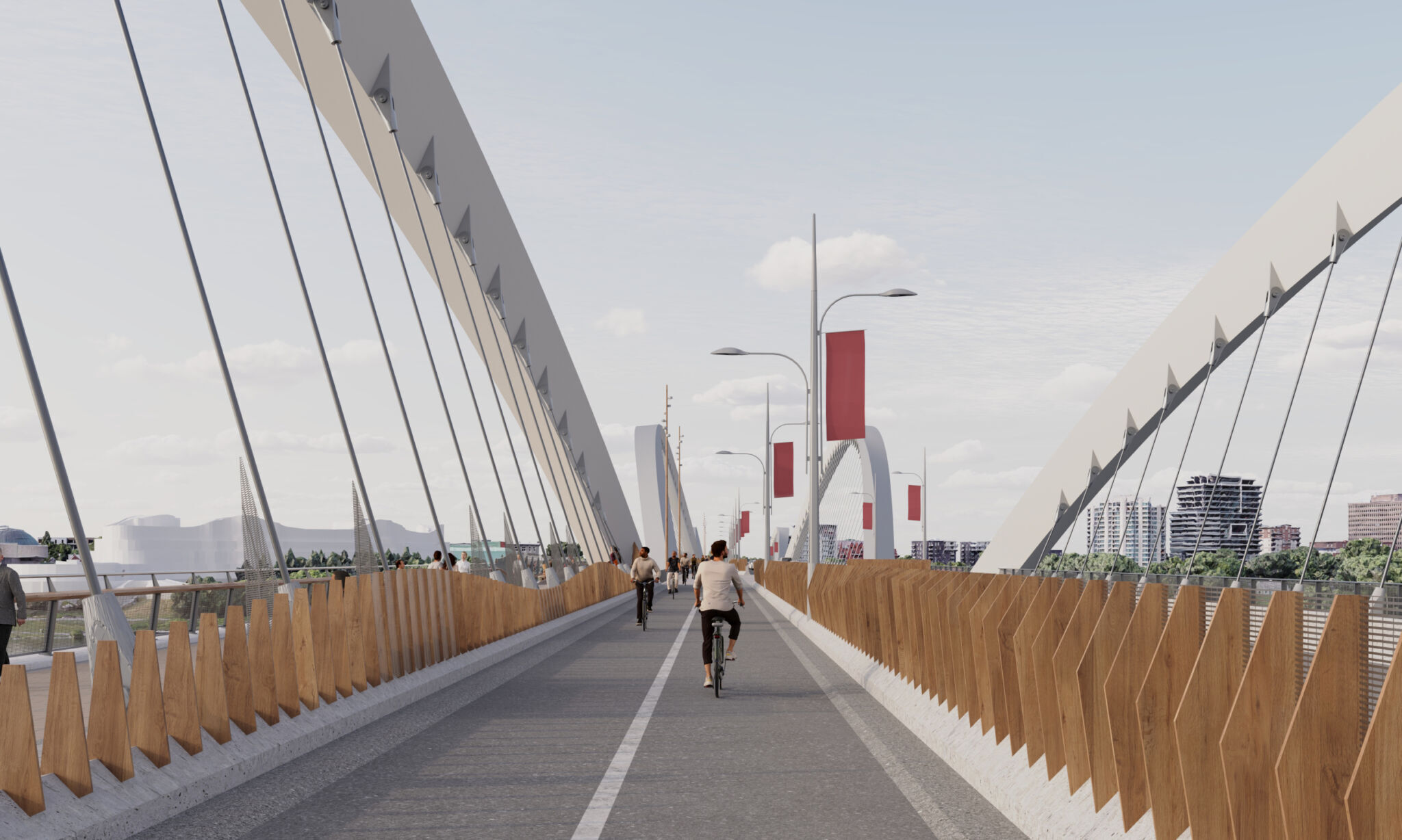 View of the cycle path on the bridge from a cyclist’s perspective. The bridge has large, curved support structures and wooden screens along the protective barriers on each side. Several cyclists and pedestrians are on the path. The background includes buildings, greenery, streetlights and red banners hanging from poles along the bridge.